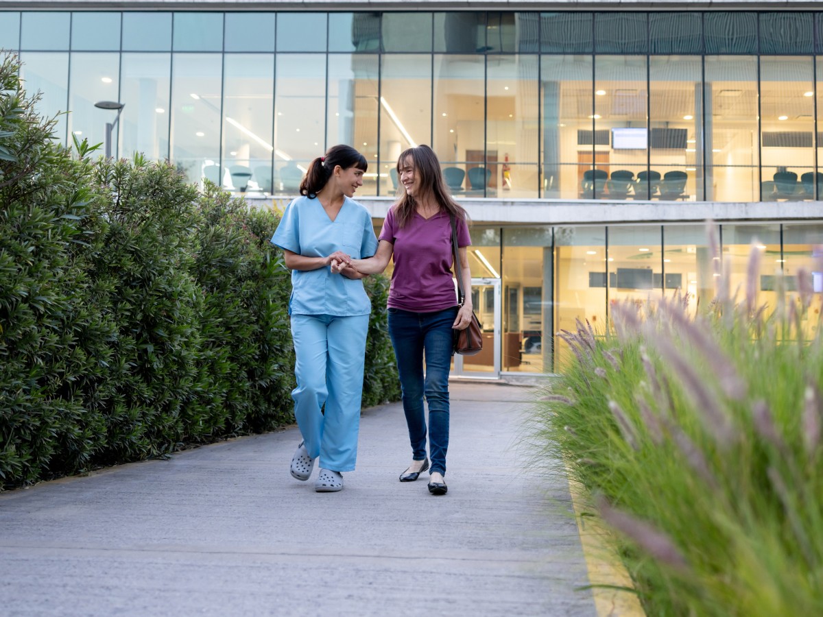 nurse walking with patient outside healthcare facility