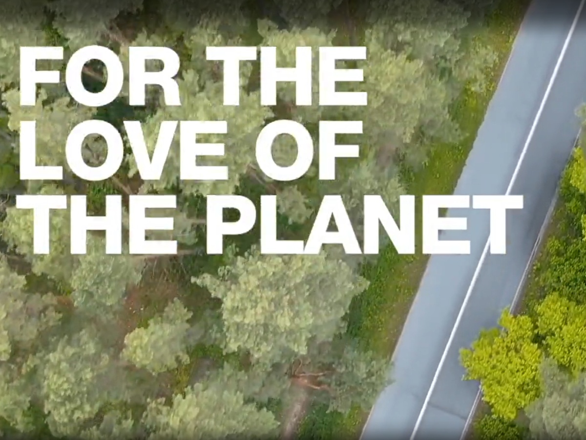 for the love of the planet text overlaid a road in forest