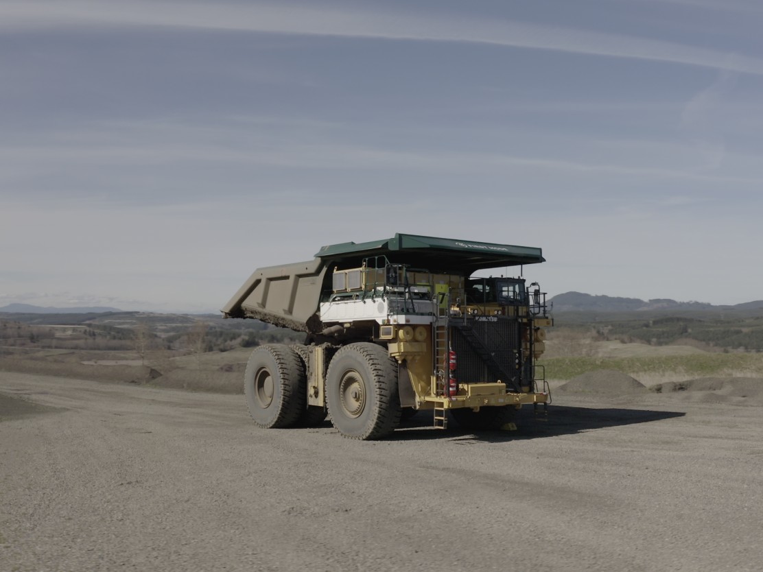 Large mining haul truck driving on an open pit mine road