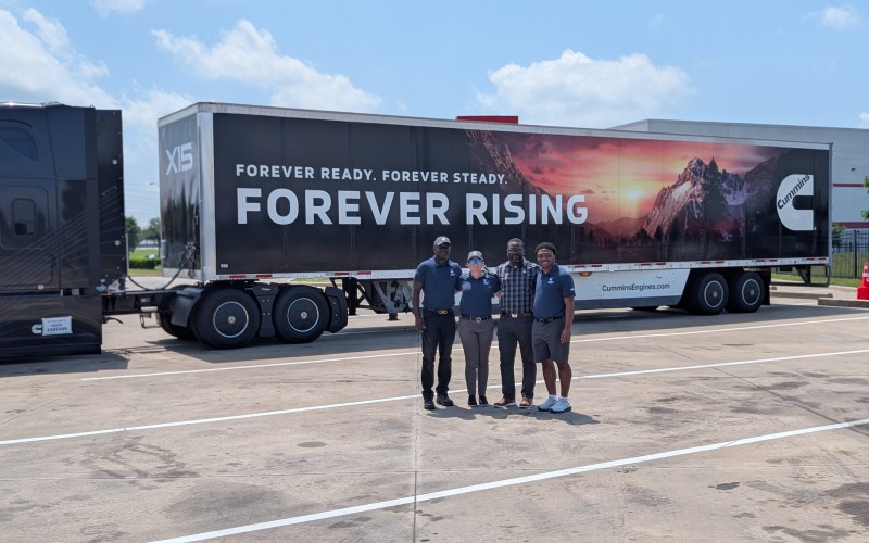People posing in front of a Forever Rising branded truck by Cummins