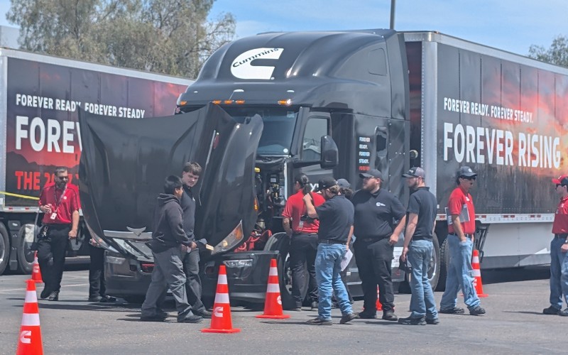 People looking at an engine inside of a truck at the Forever Rising Tour