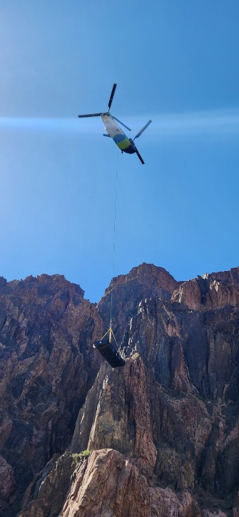 helicopter with rope and crate dropping off supplies