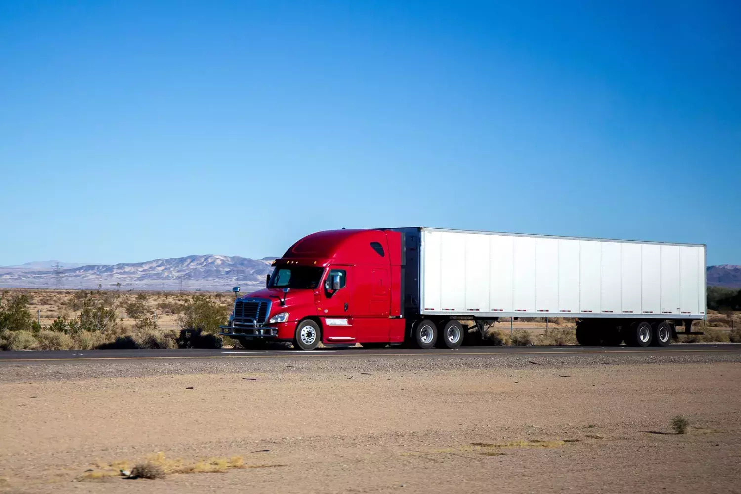 Red truck driving in desert