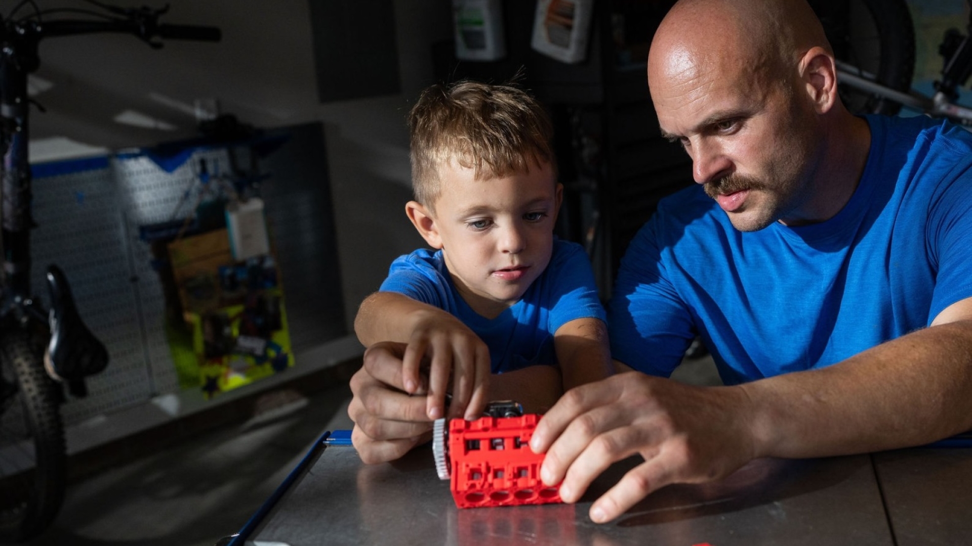 A man and boy work together on a Cummins lego engine