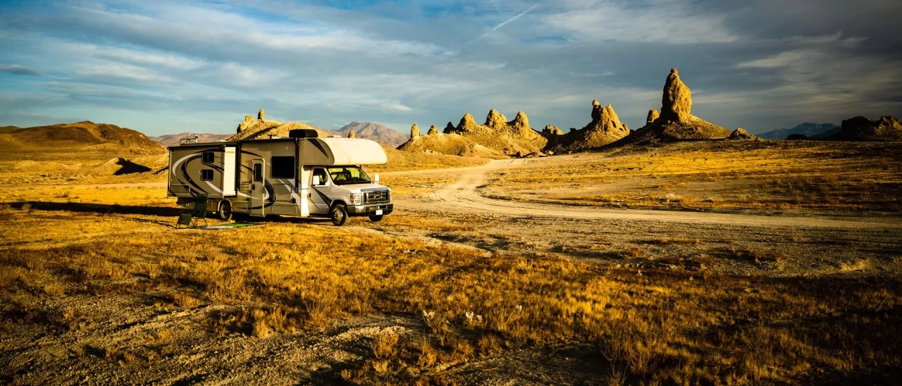 rv parked on dirt road in desert