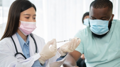 nurse giving patient shot with needle