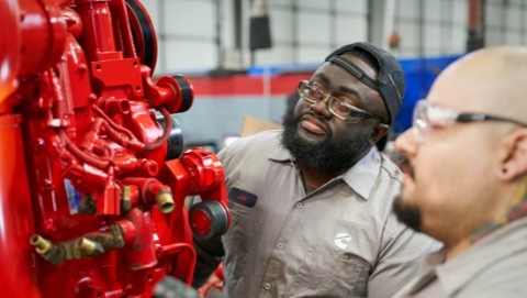 Two Cummins techs looking at an engine