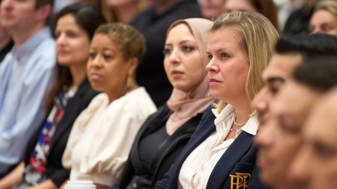 employees sitting side by side in townhall meeting