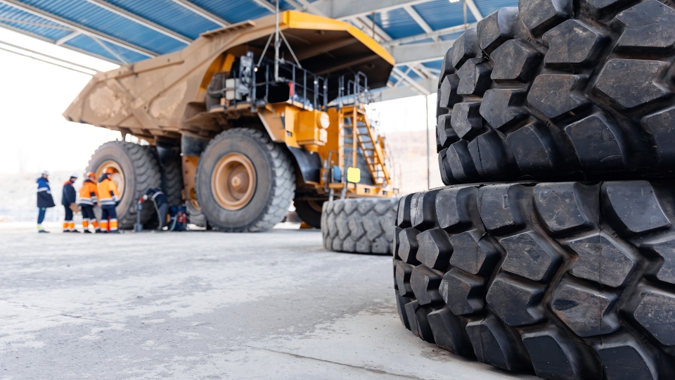 Mining dump truck with large tires in front of it