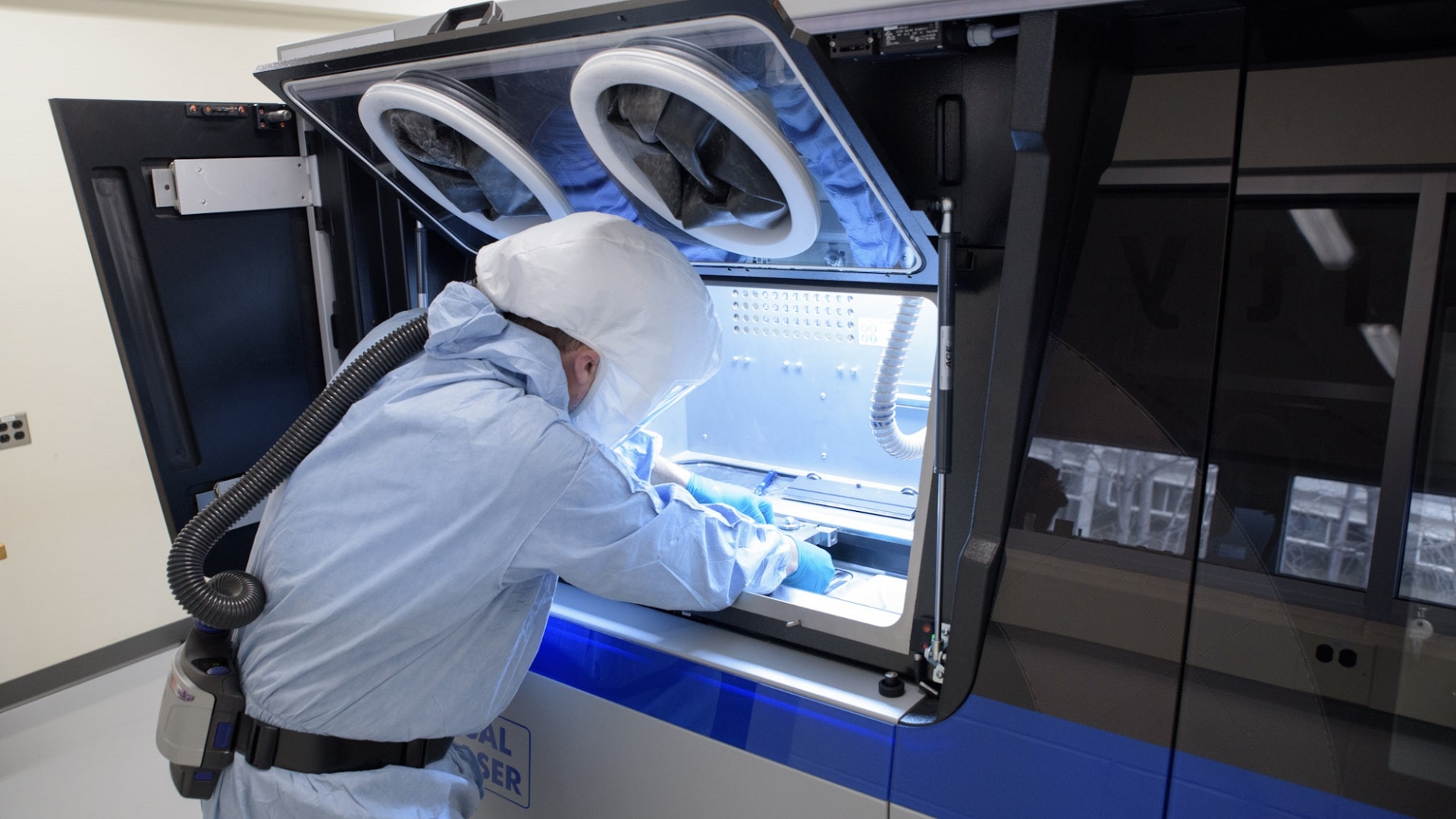 Cummins employee Devin Hunter cleans one of the company’s 3D printers at the Cummins Technical Center in Columbus, Indiana, before another round of printing. Metal 3D printers could revolutionize manufacturing.