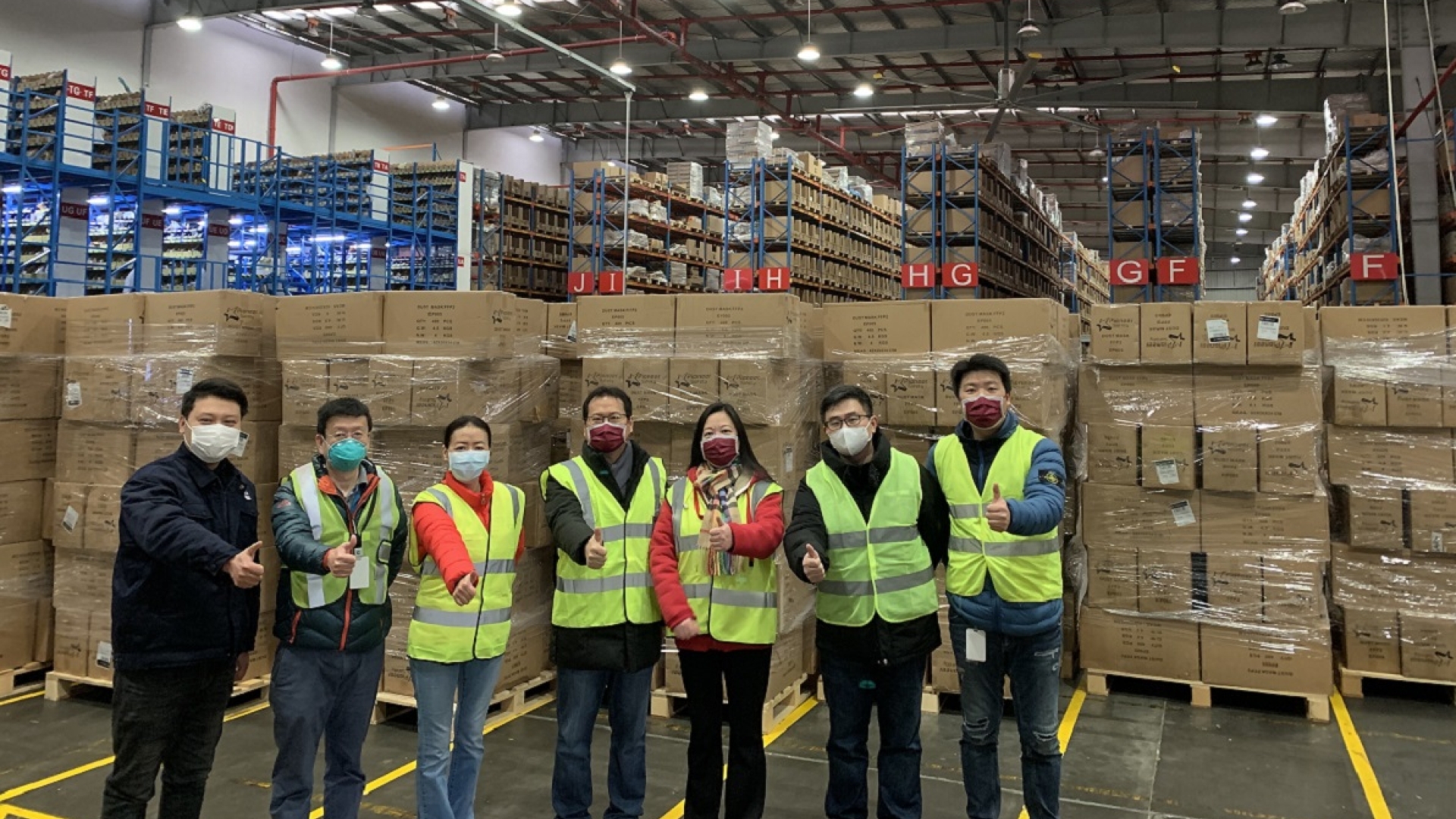 Cummins employees in Shanghai stand in front of one of the shipments of masks.