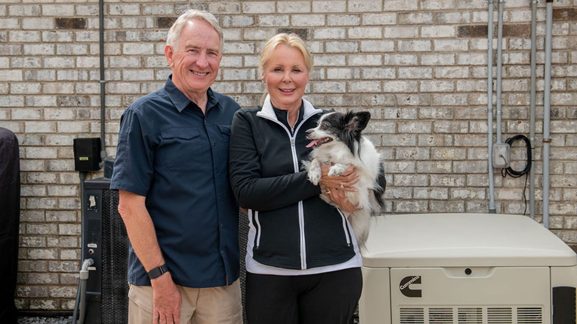 Family with dog standing next to Cummins home standby generator