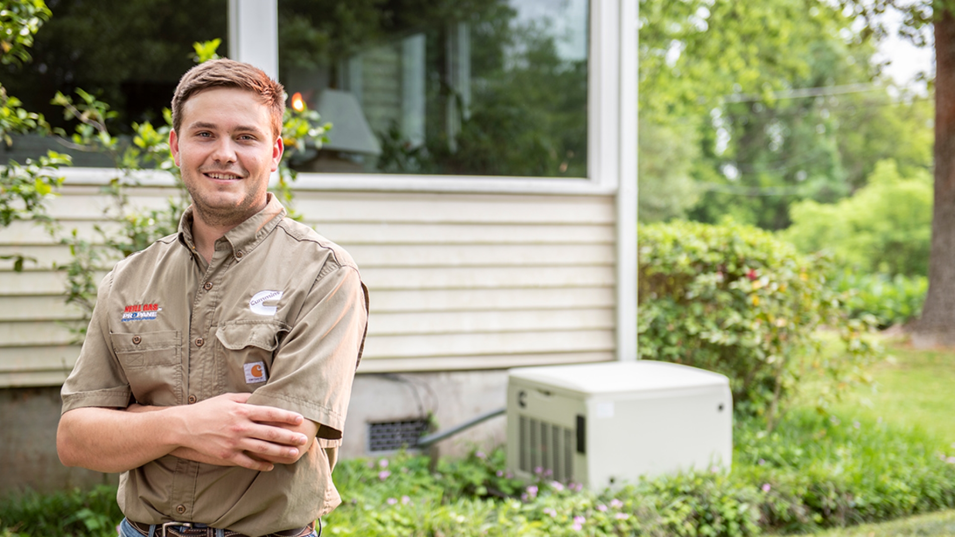 Cummins dealer smiling next to home generator