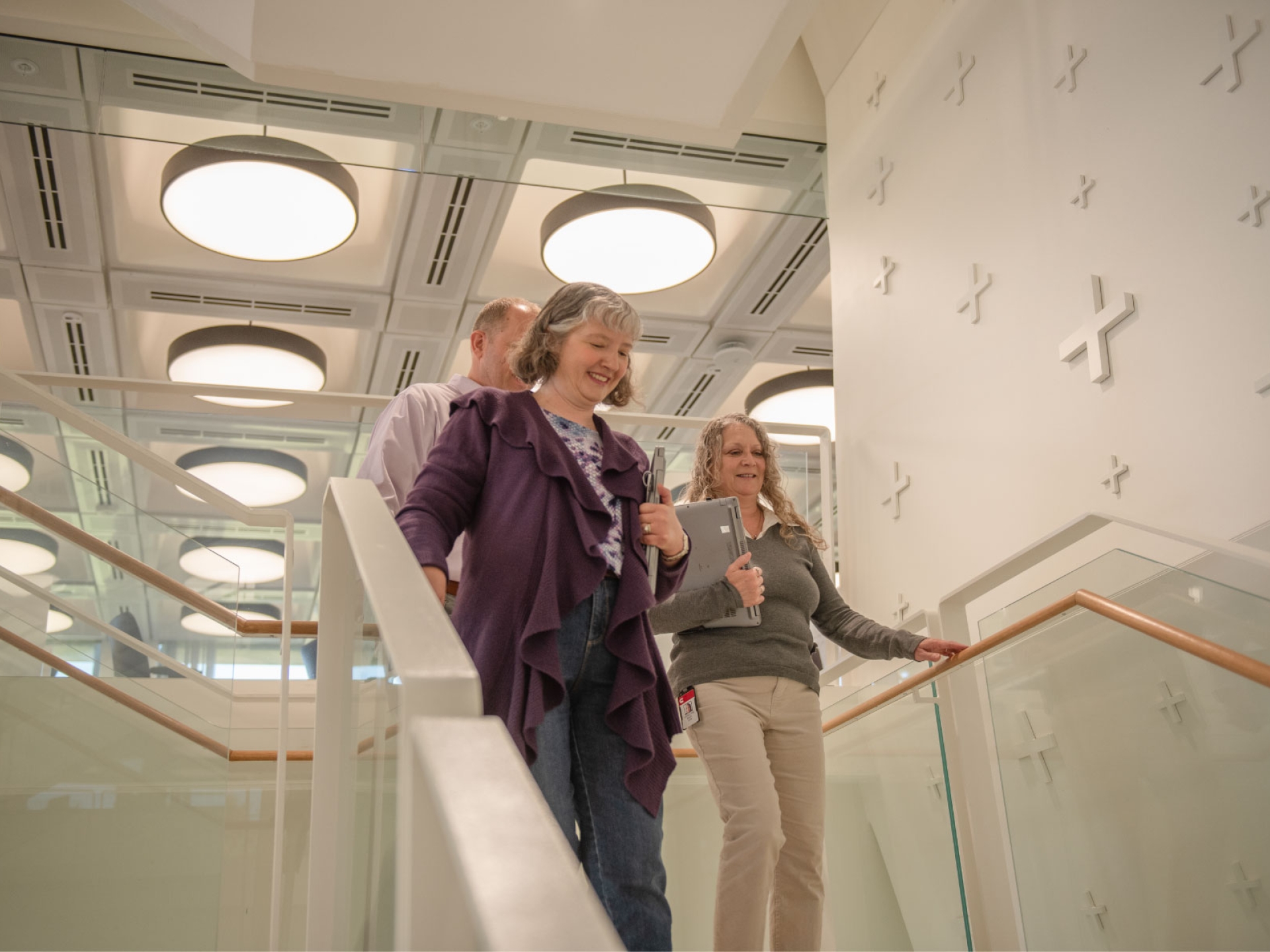 Jennifer, a Cummins engineer, walks down the stairs with two colleagues in a modern office