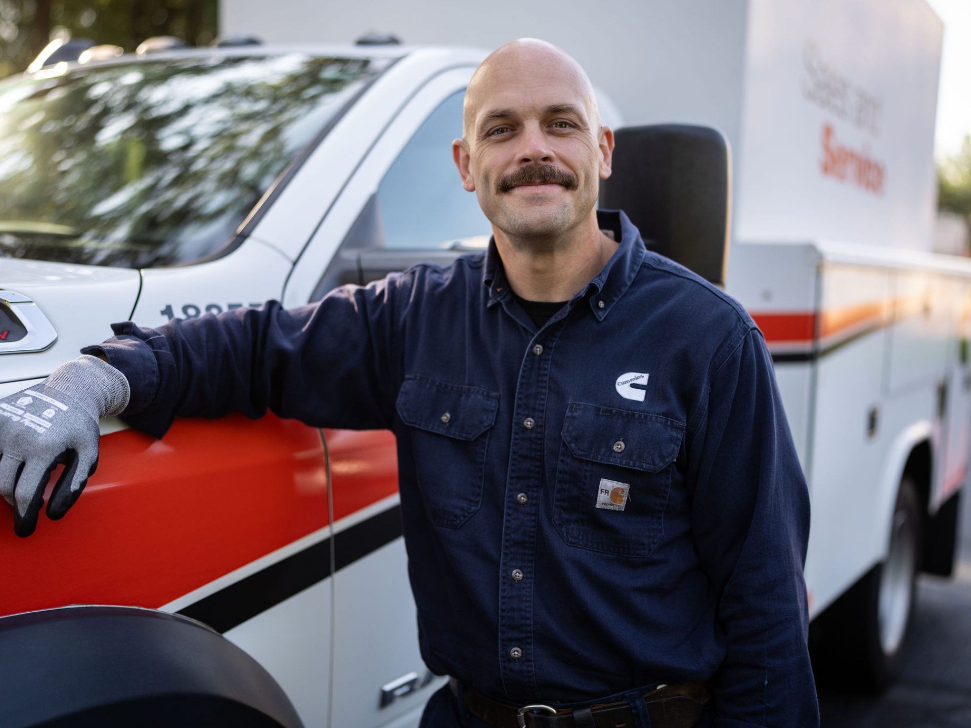 Field service technician standing beside a service truck