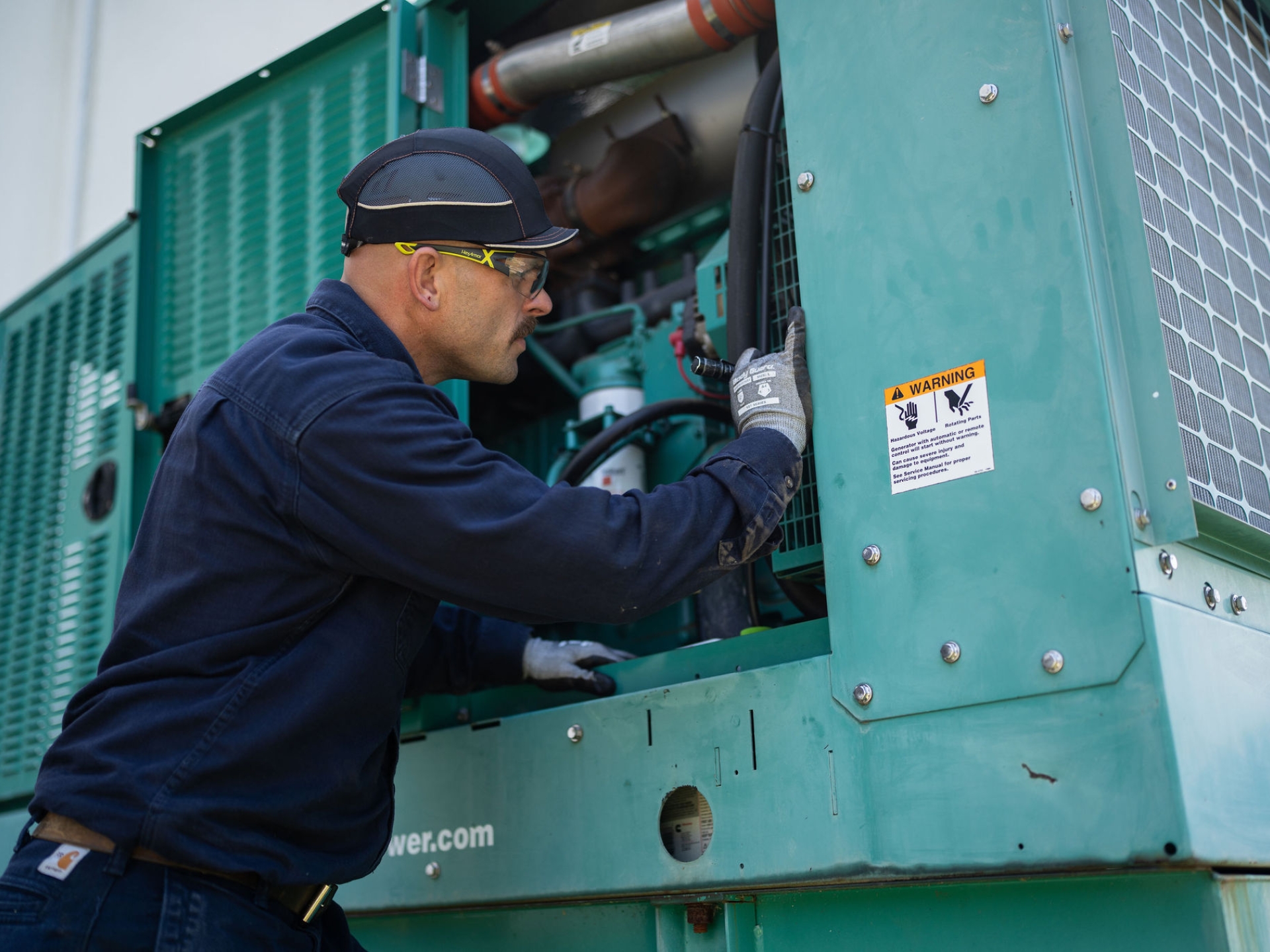 Field service technician inspecting generator equipment on-site