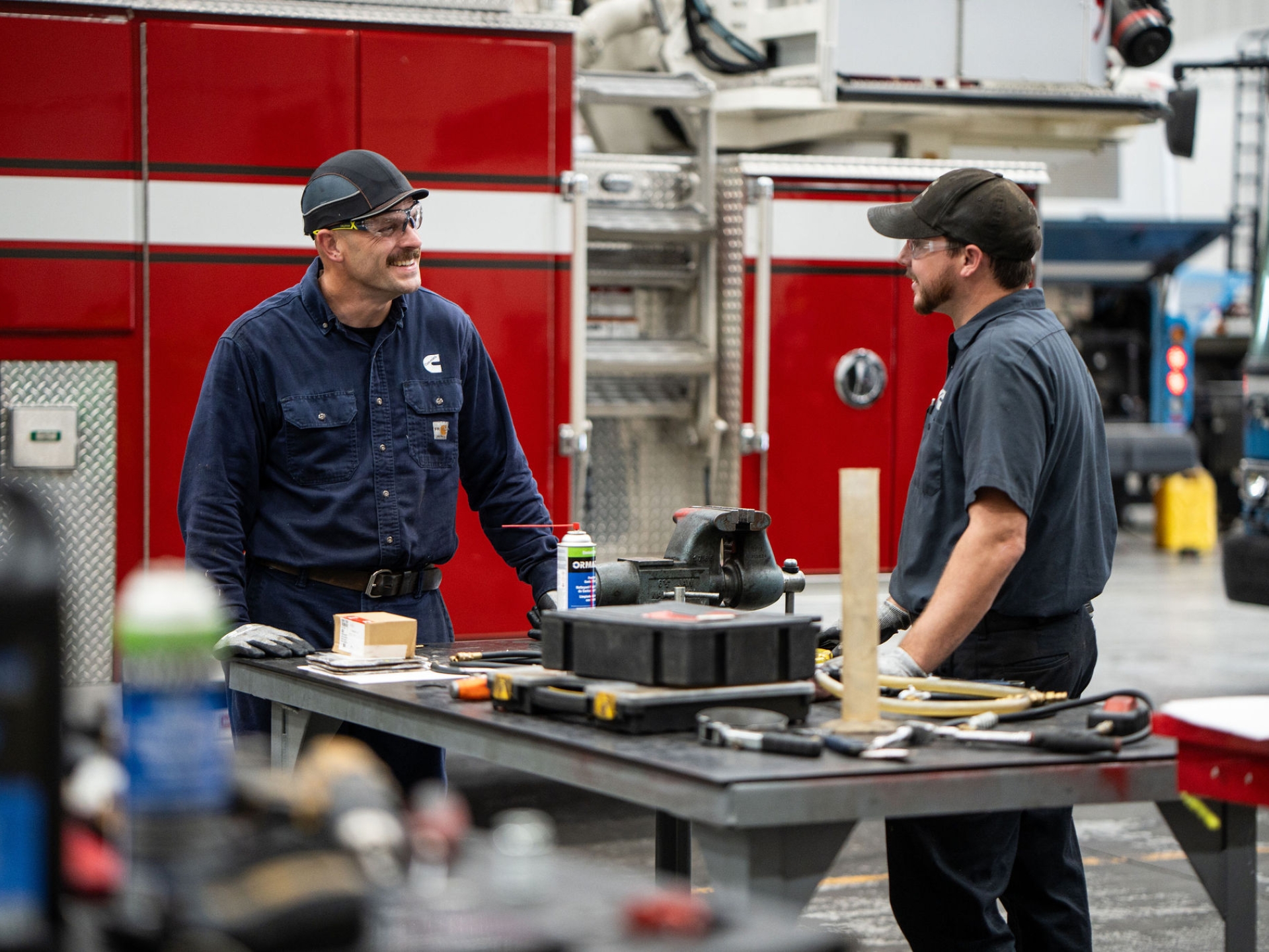 Two technicians discussing repairs in a service shop