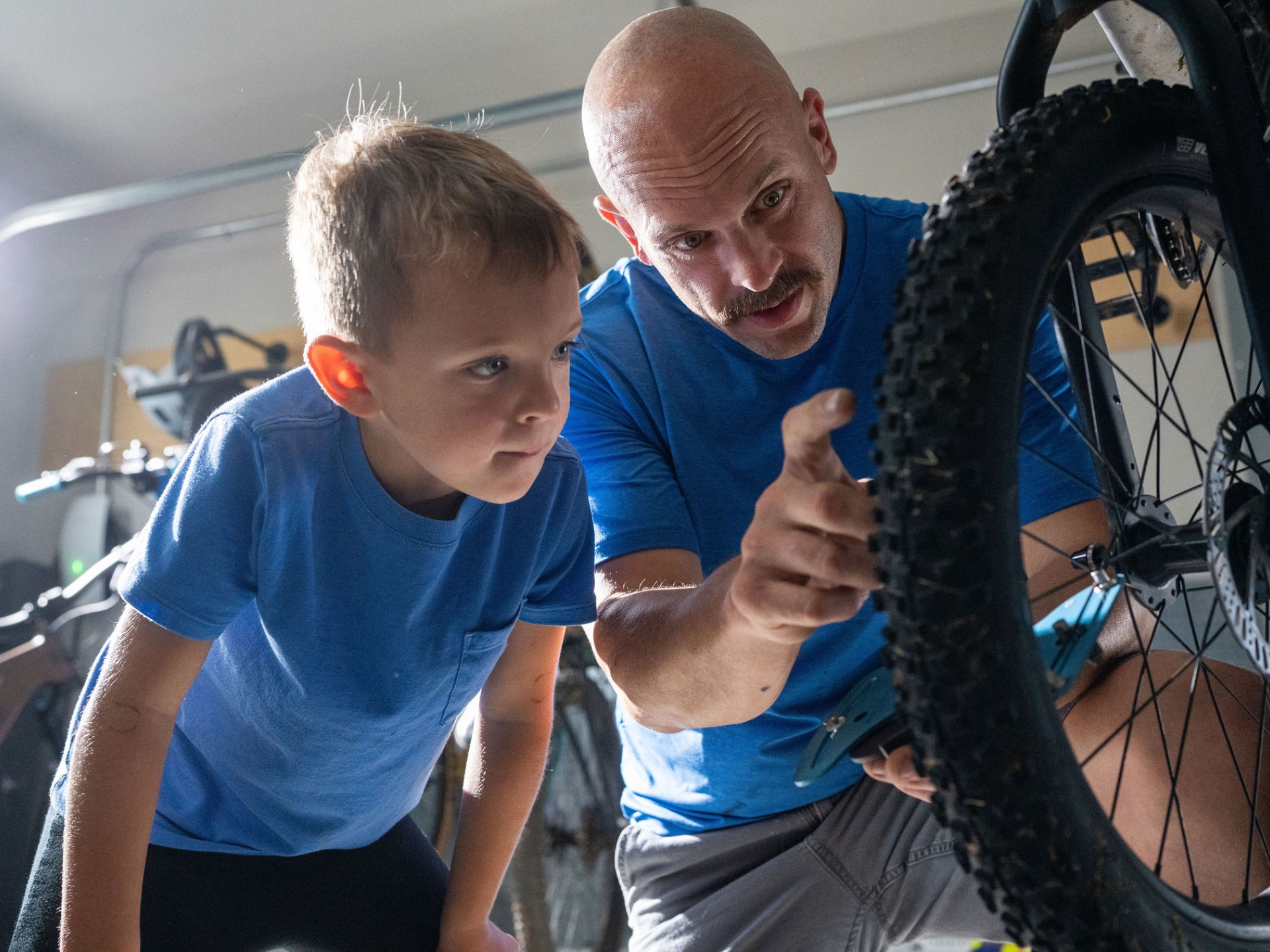 Cummins field service technician working on a bike with his son in a garage