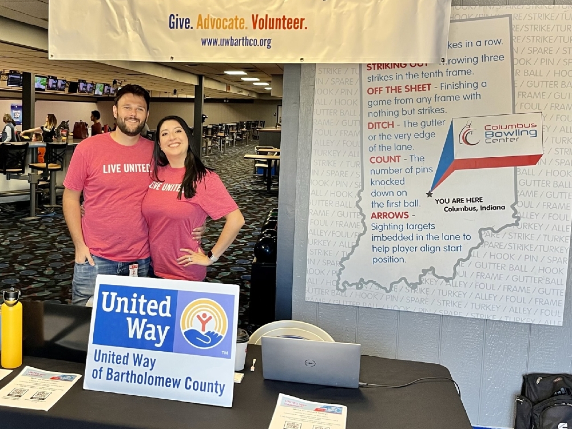 Amy stands at a United Way table at a community event.