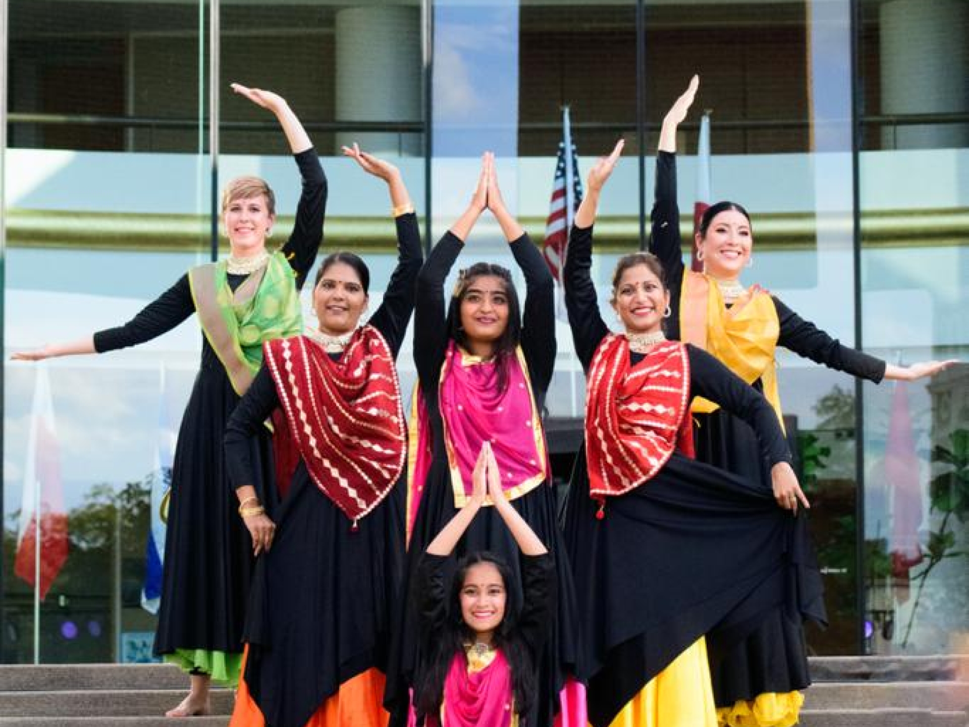 Amy and a group of dancers perform outside a building as part of her community engagement story.