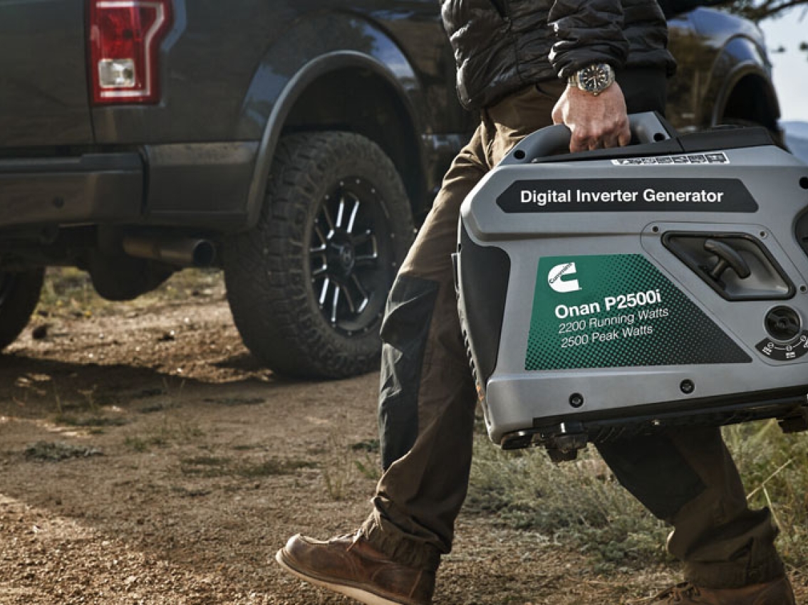 A person carries the cummins portable p2500i generator