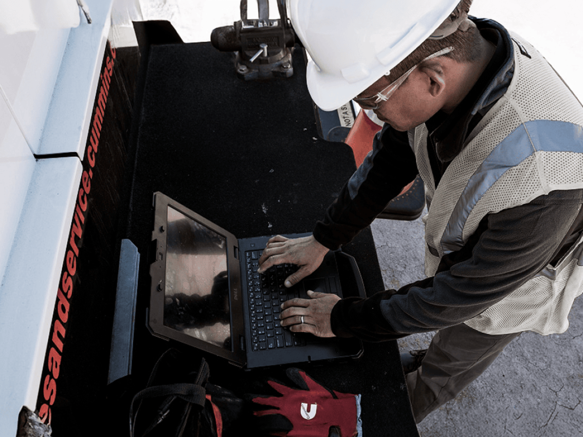 technician looking over at service report on computer
