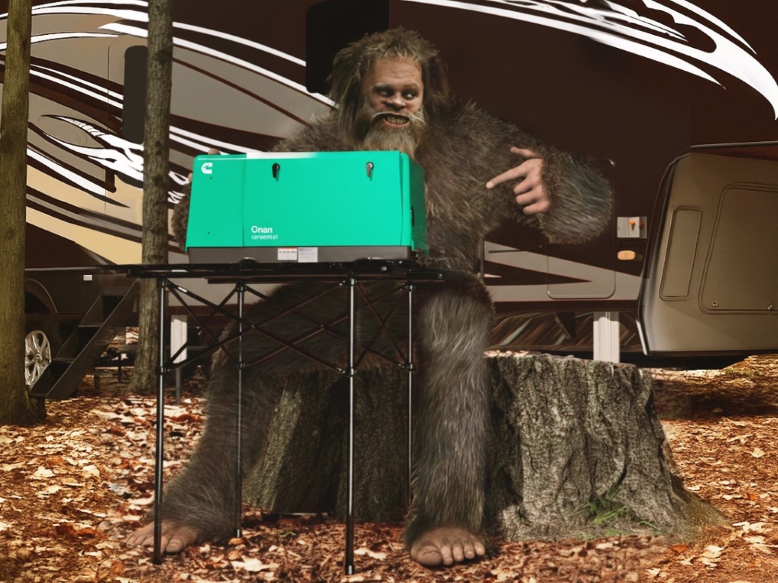 bigfoot sitting at camp table with onan generator