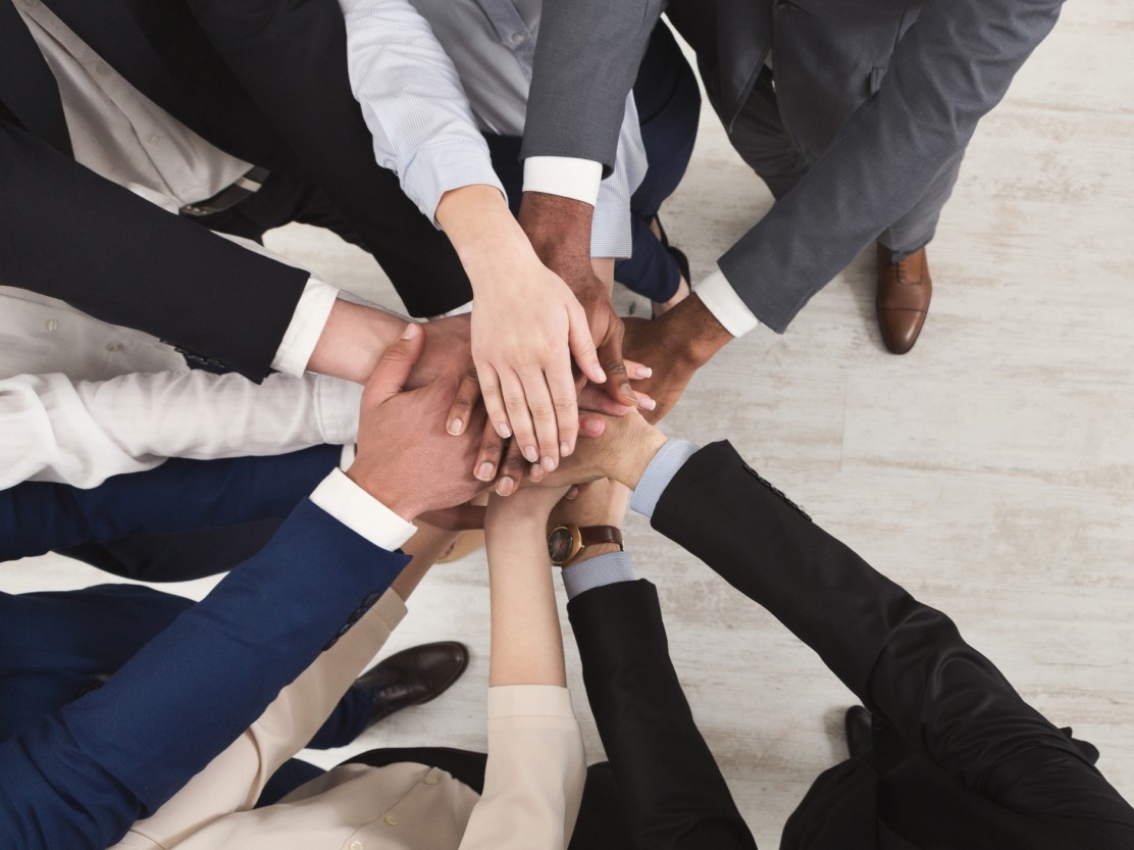 Team grouped up with their hands together in a circle