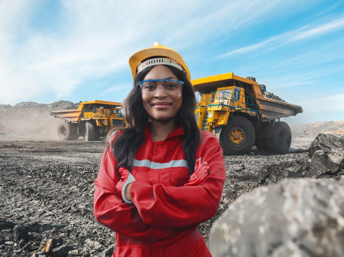 Woman on mining site with diggers behind her