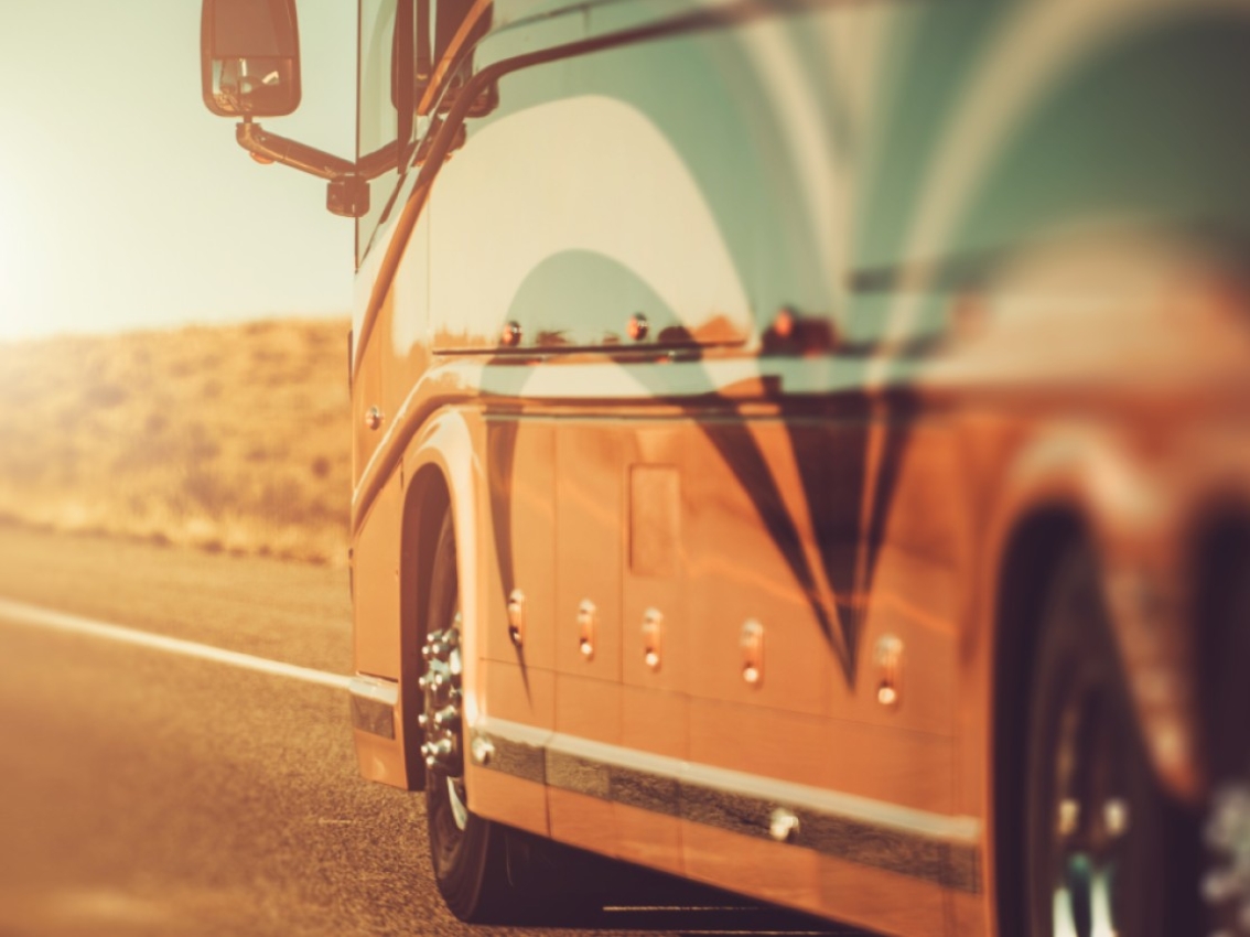 RV driving though desert with sun reflection showing