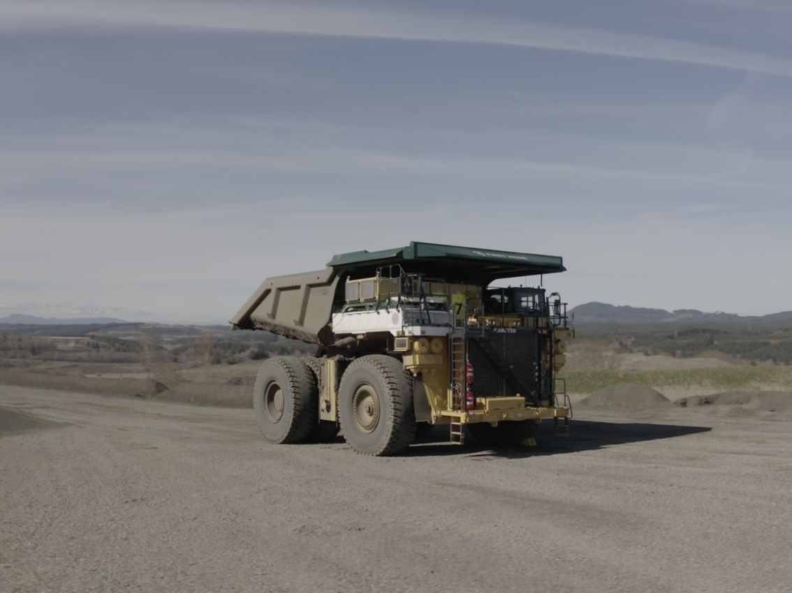 Large mining haul truck driving on an open pit mine road