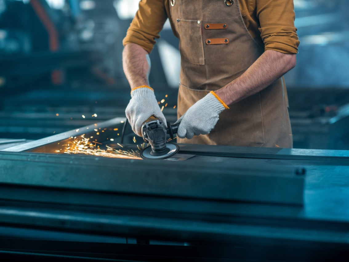 industrial worker with saw creating sparks cutting metal