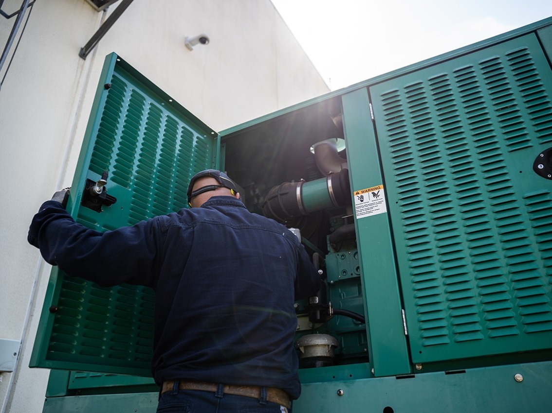service technician looking at generator