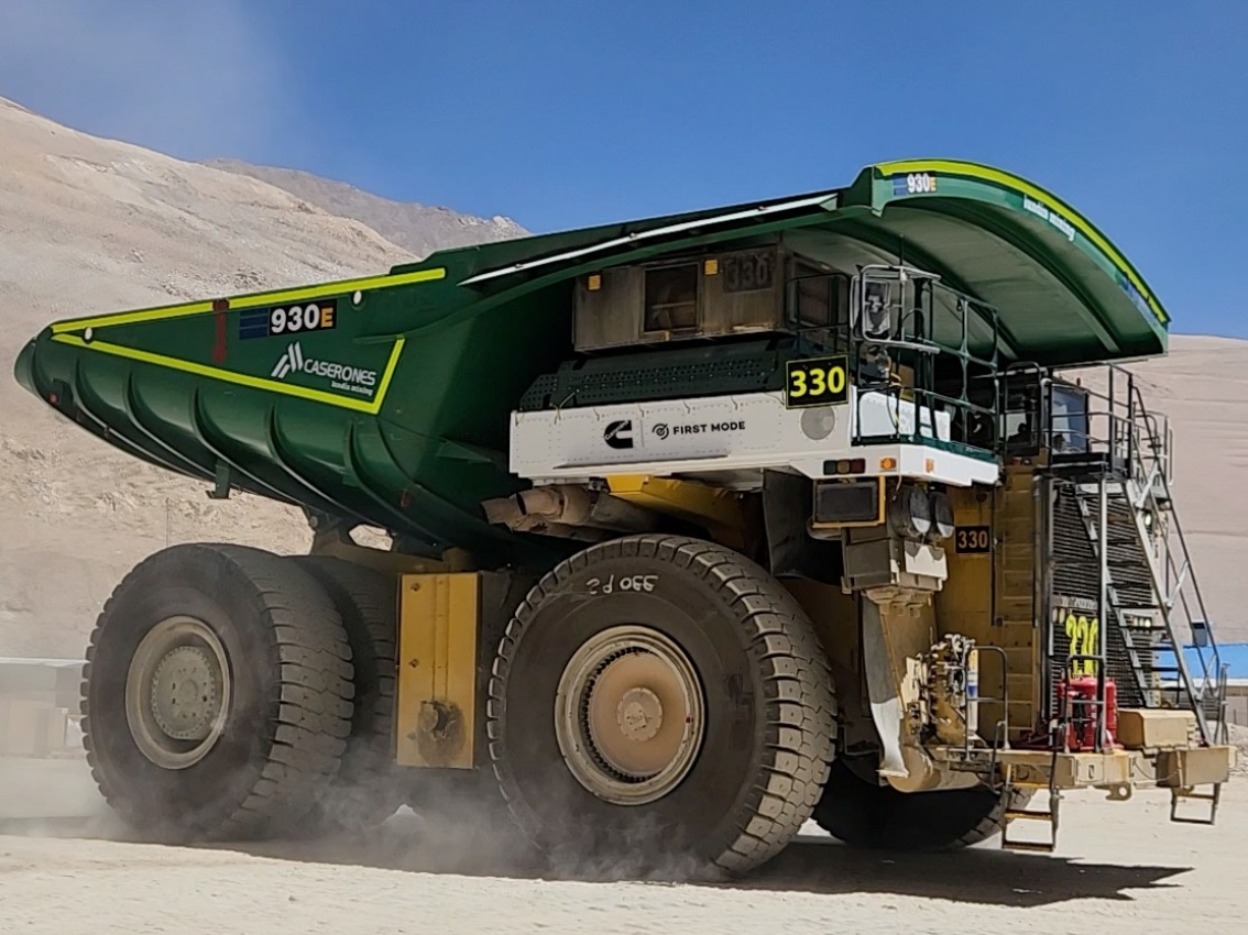 Large mining haul truck driving through a dusty open-pit mine