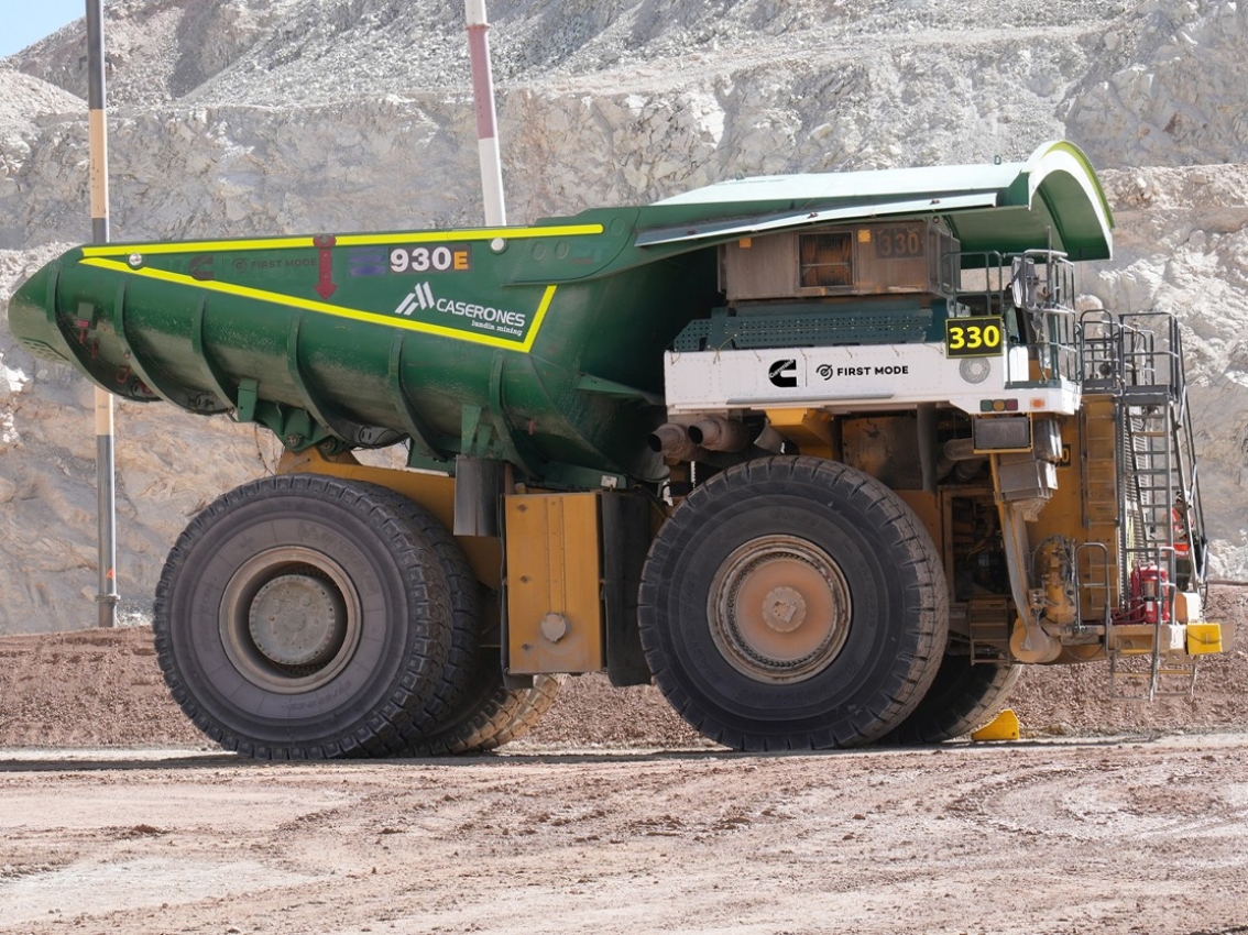 Large mining haul truck with a green haul body parked on a mine site