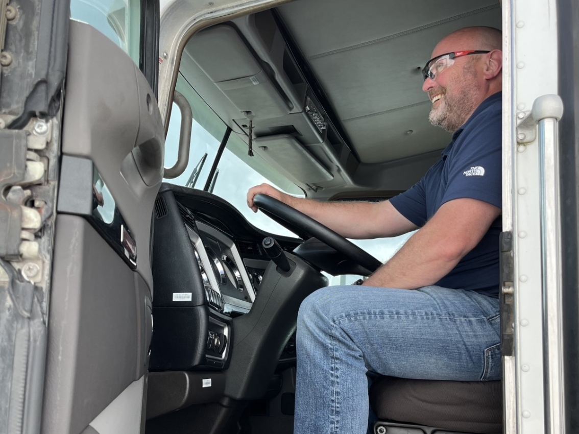 Reggie Witt seated in the driver's seat of a commercial truck as part of the Cummins Body Builder Program
