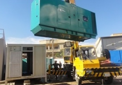 The generator is lifted to the site during installation.